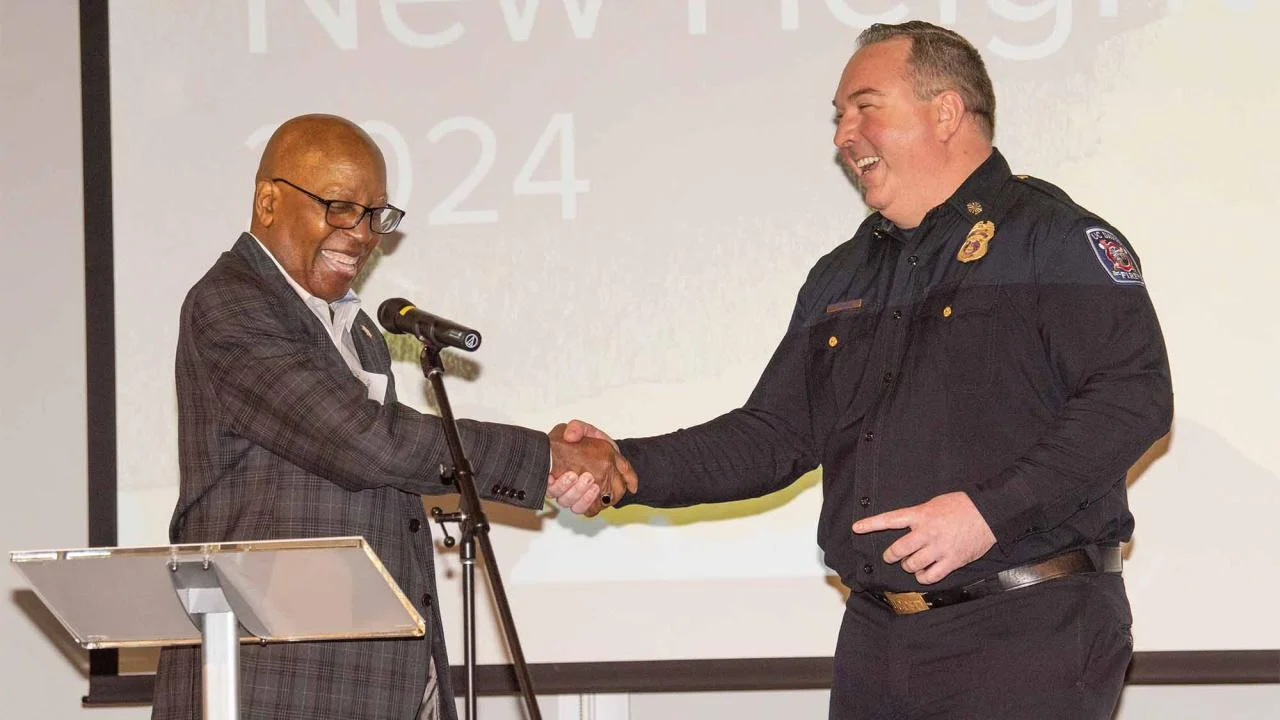 Police Chief Emeritus Calvin Handy congratulates Fire Chief Nate Trauernicht at Soaring to New Heights ceremony.