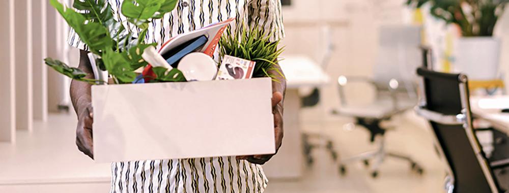 person holding box of personal items